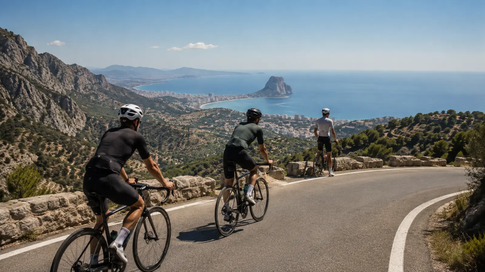 Road cyclists on the Bèrnia mountain road with views towards Calpe and the Peñón de Ifach