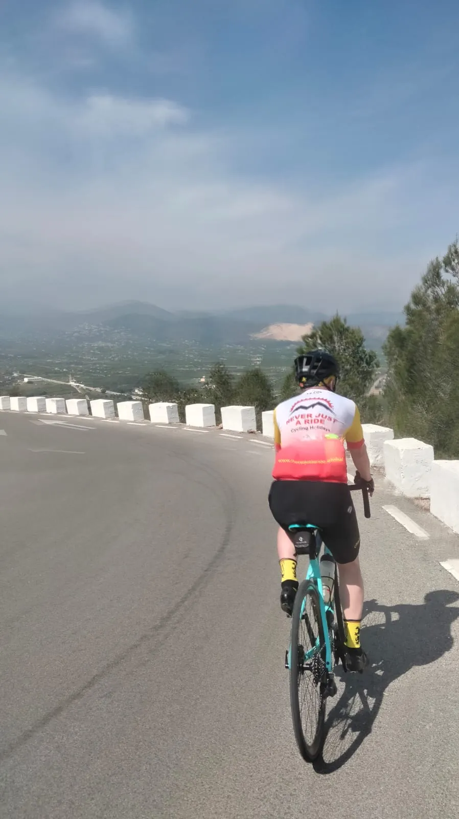 Road cyclist descending a winding Costa Blanca road